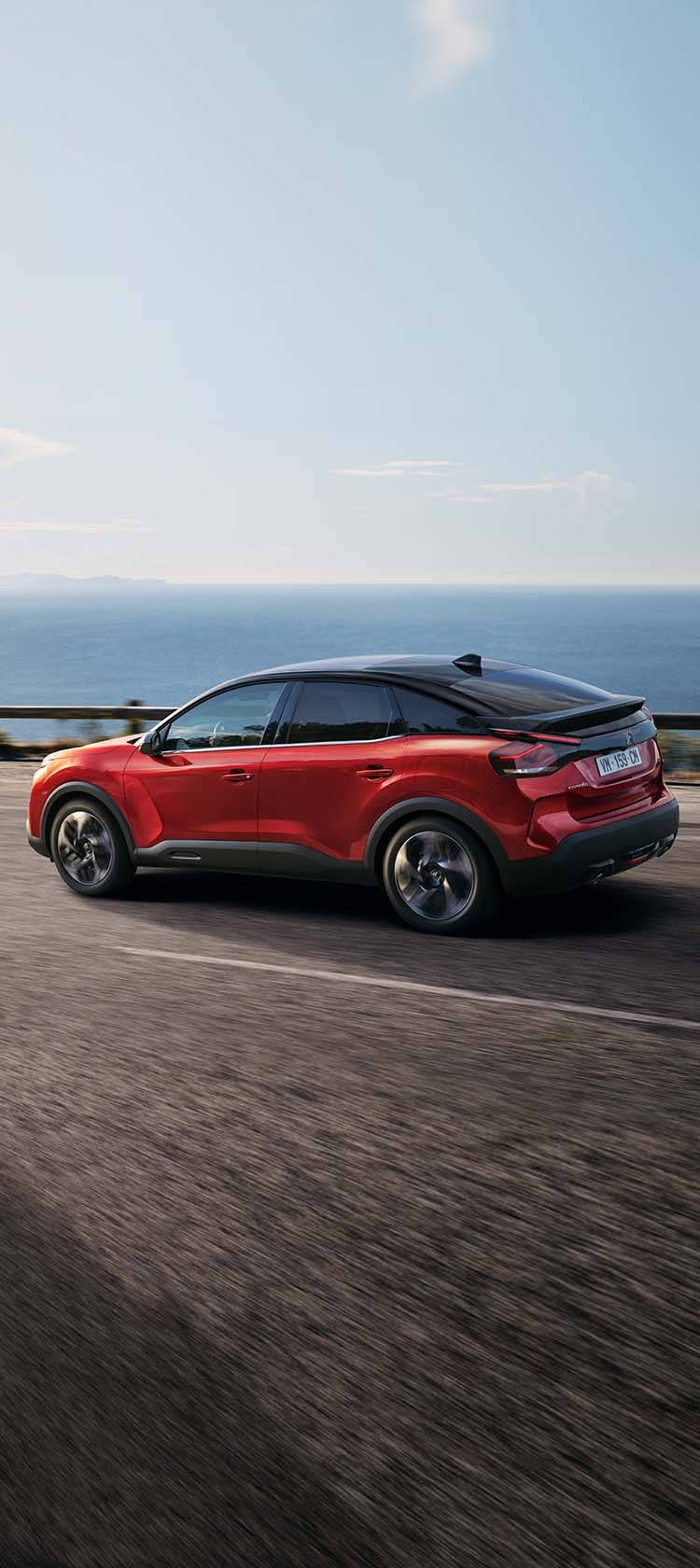 Citroën C3 Rouge avec coucher de soleil et ville en fond